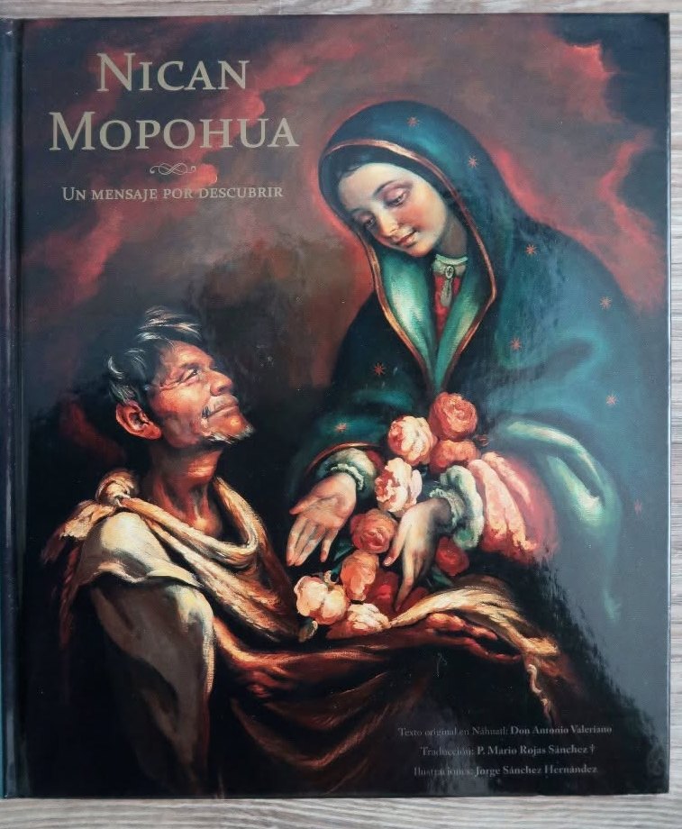 Ejemplar de tapa dura del Nican Mopohua sobre una duela clara; en la portada, la Virgen entrega las rosas a Juan Diego